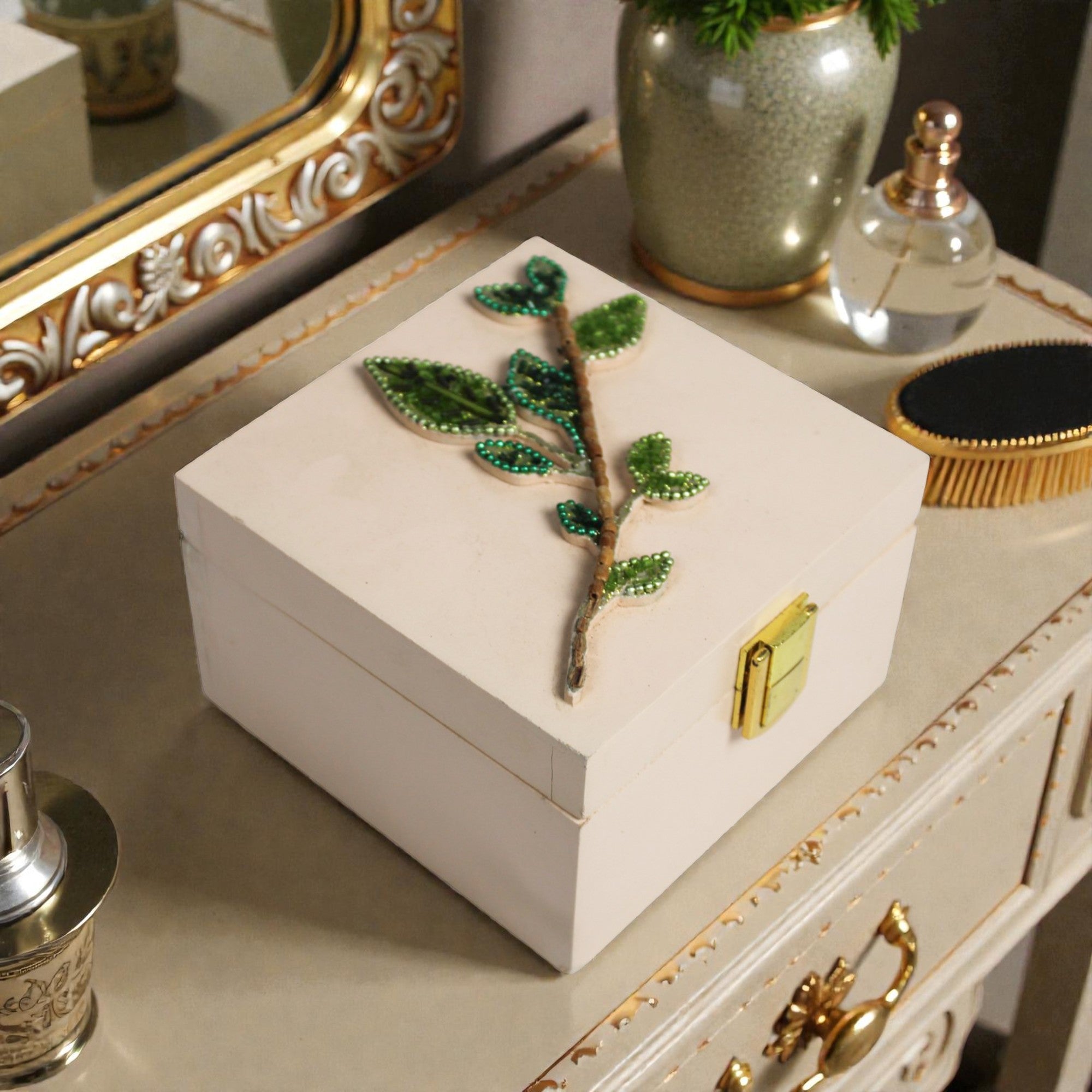  Decorative white box with green embellishments on a vanity table. 
